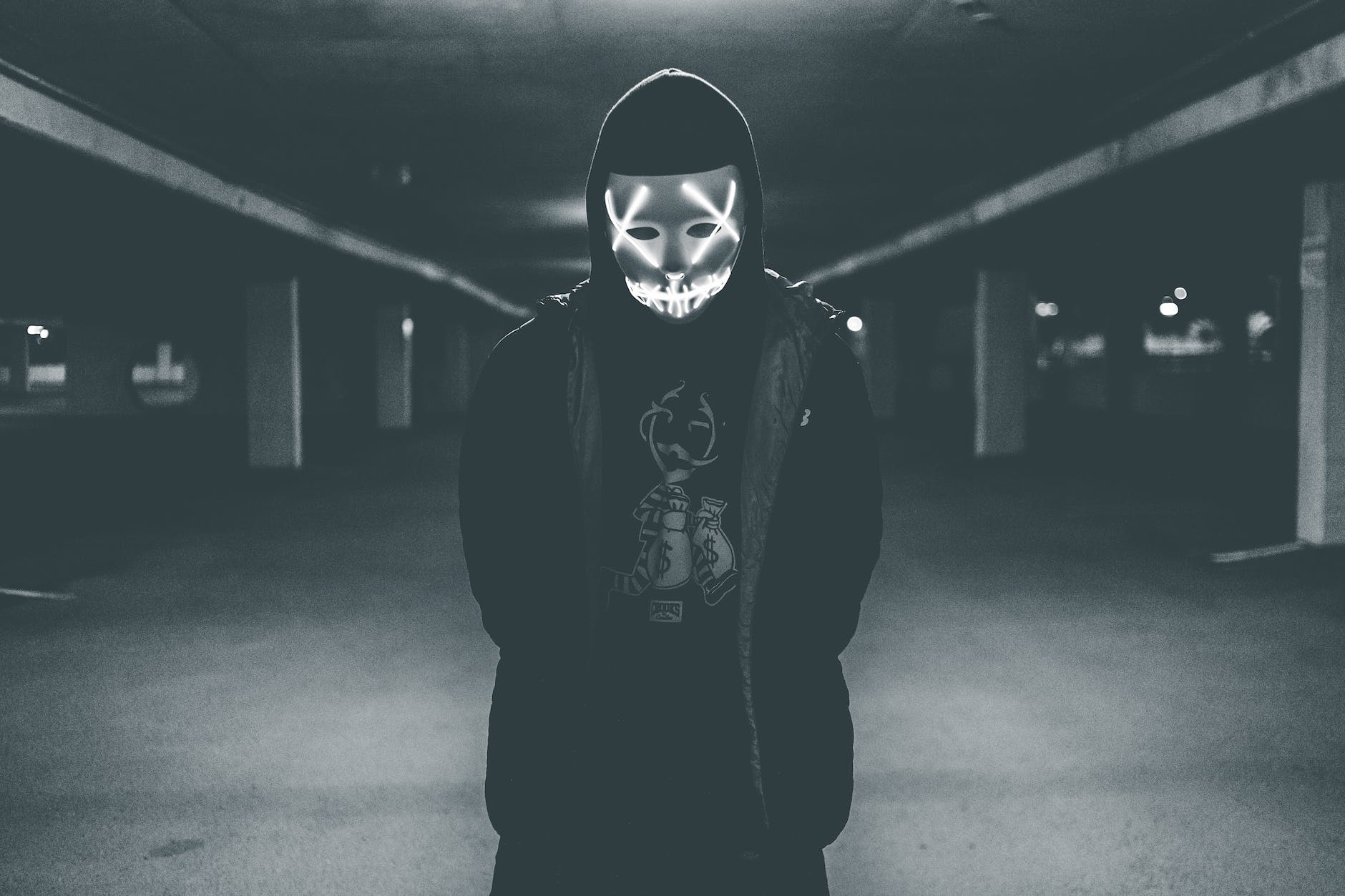 man wearing hood and mask with neon lights